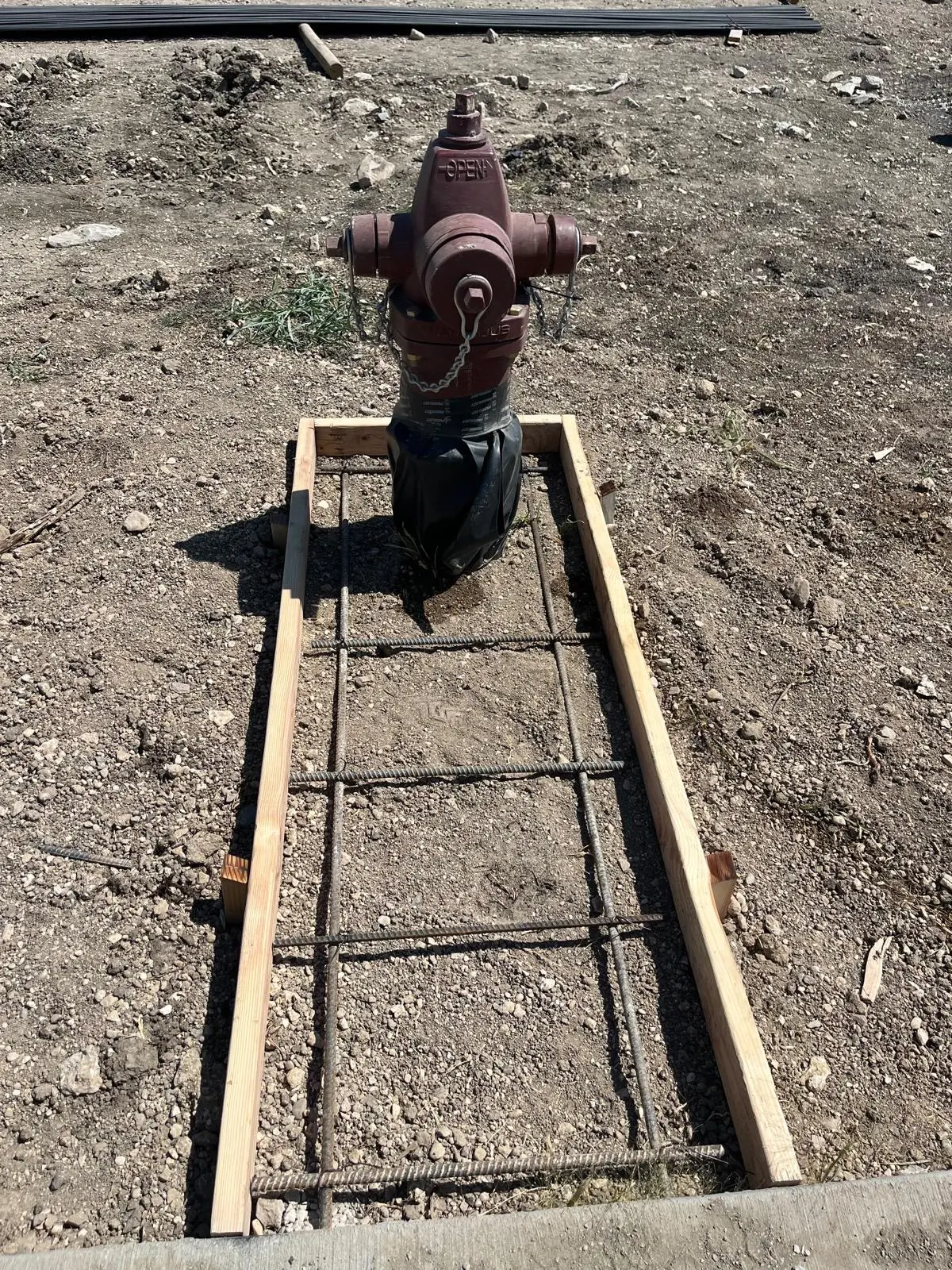 Fire hydrant with formed concrete pad and rebar ready for pour