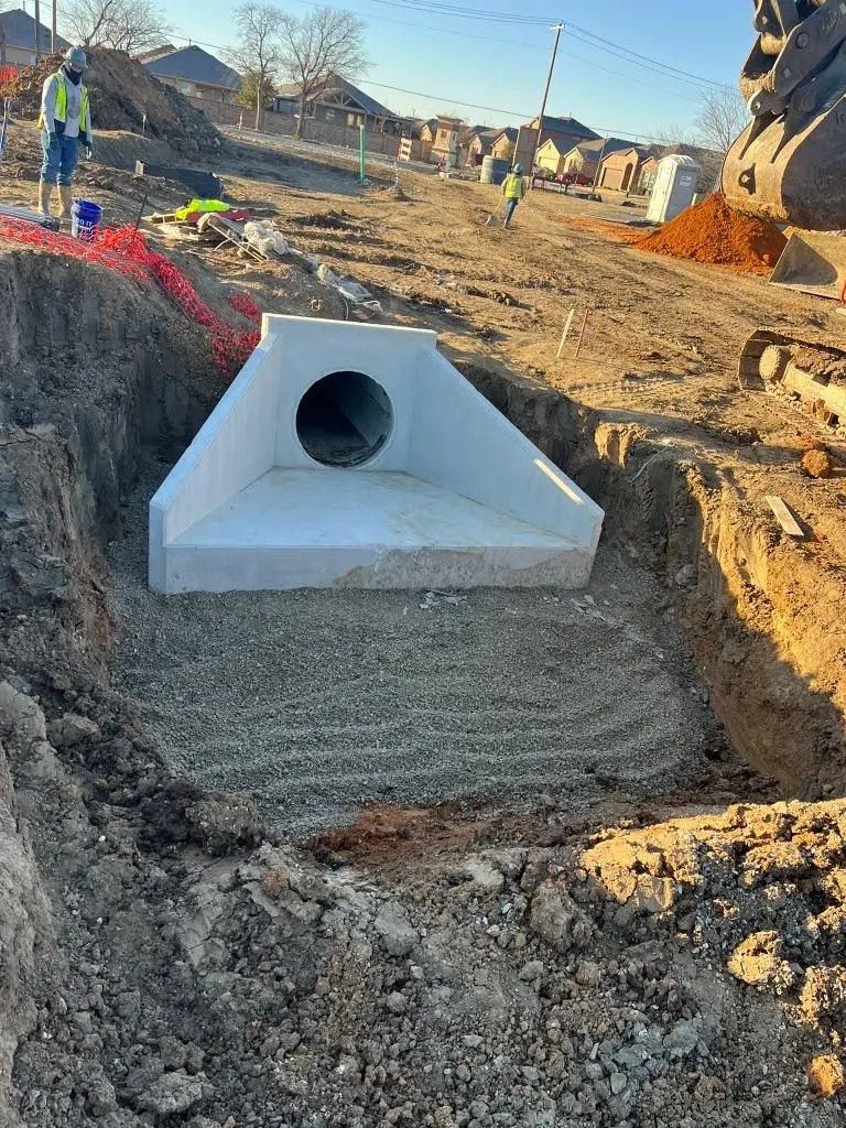 Precast concrete headwall storm outfall set on graded rock