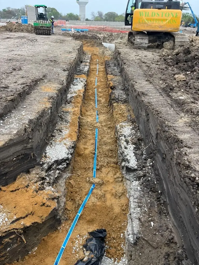 Water service line trench excavation with excavator on a commercial site